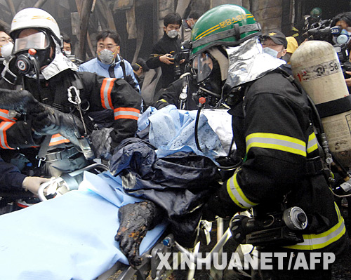1月7日,在韓國京畿道利川市,消防員從爆炸現(xiàn)場抬出一具尸體。